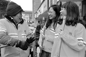 1月8日，22歲的王雪菁（右）和23歲的陶晨露（中）陪著她們的環(huán)衛(wèi)工人師傅鄧桂鸞聊天 新華社發(fā)