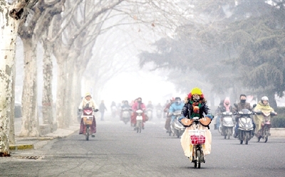 昨天上午，中原路，行人在霧霾中騎車出行，很多行人戴上了口罩。