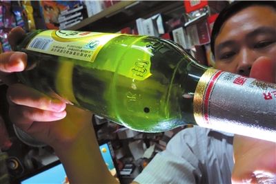 這瓶未開封的燕京啤酒內(nèi)有一顆黑色懸浮物。京華時報記者 徐曉帆 攝